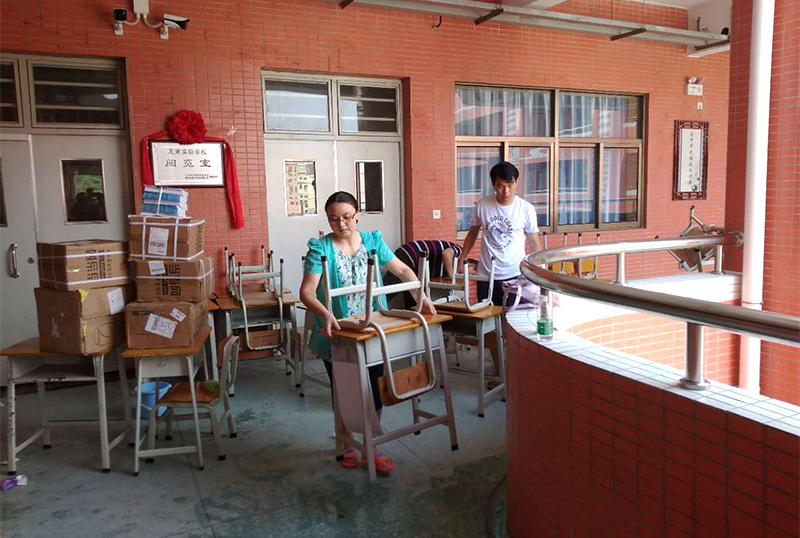6686体育首页志愿者及家长用消毒液擦拭桌椅